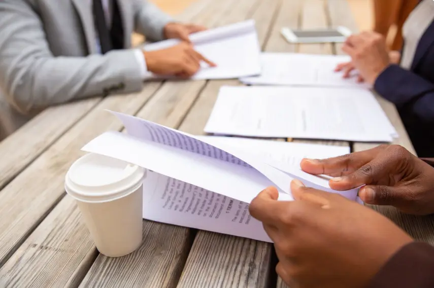 Business professionals reading agreement text